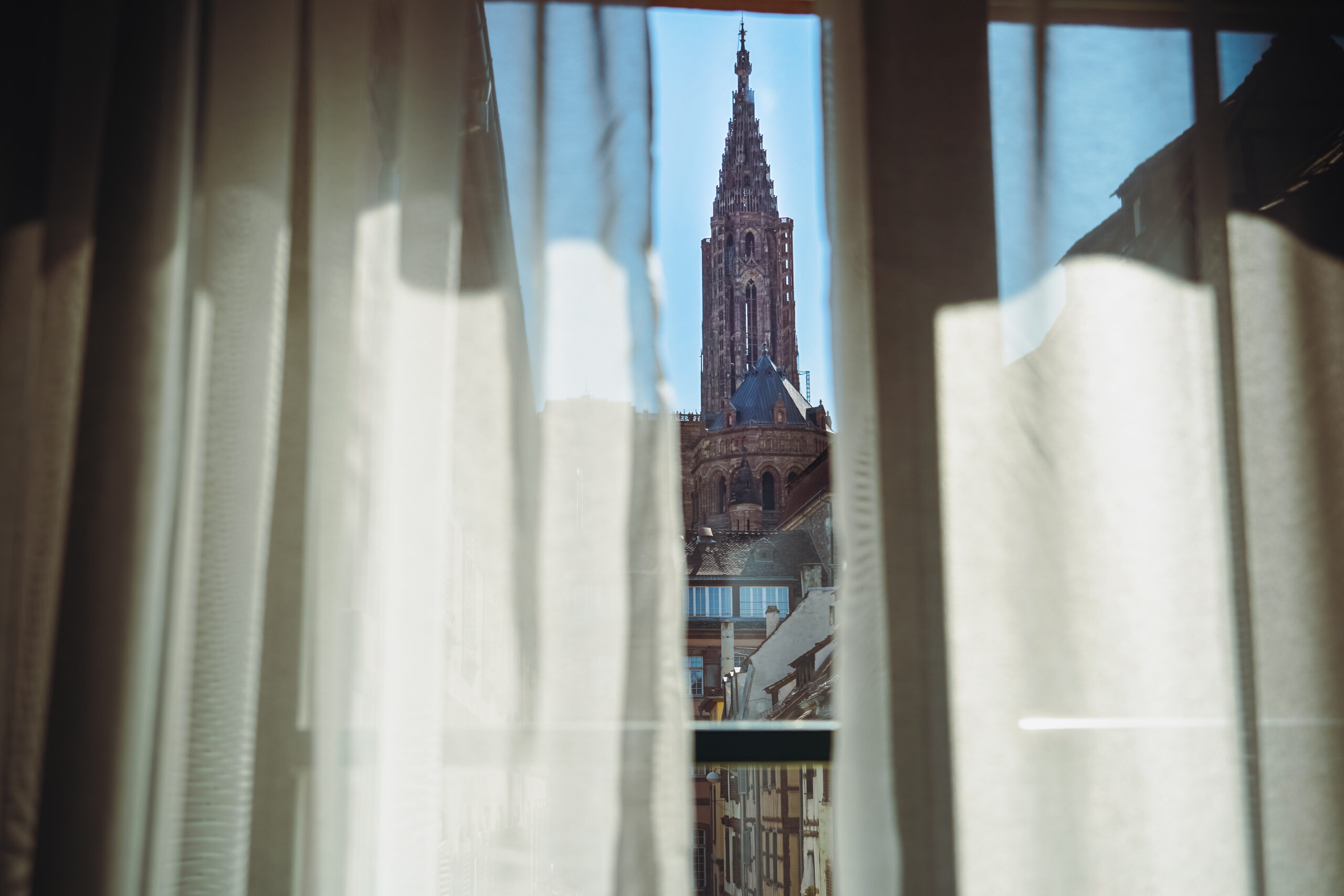 Flèche de la cathédrale de Strasbourg vue à travers des rideaux